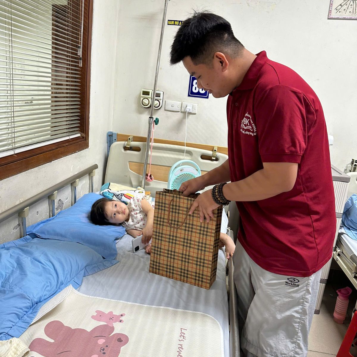 Hình ảnh chàng sinh viên trẻ trong hoạt động tặng quà cho bệnh nhi