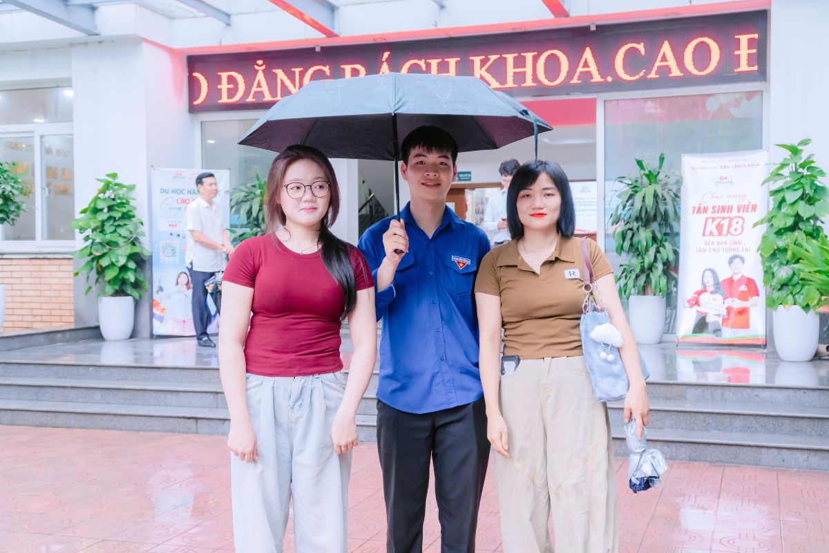 Sinh viên Hoàng Đình Chiến - TQ K17che ô đưa đón tân sinh viên và phụ huynh ngày mưa Sinh viên Hoàng Đình Chiến - TQ K17che ô đưa đón tân sinh viên và phụ huynh ngày mưa